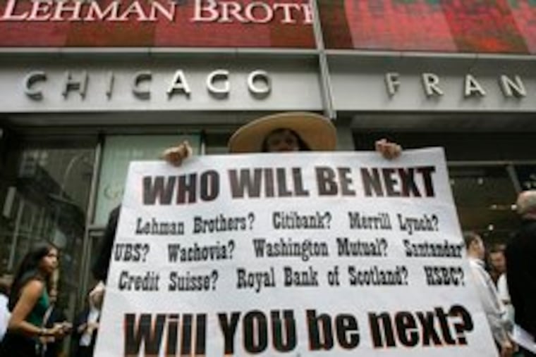 A sign held up in front of Lehman Brothers headquarters in New York yesterday underscores growing credit-crisis fears.