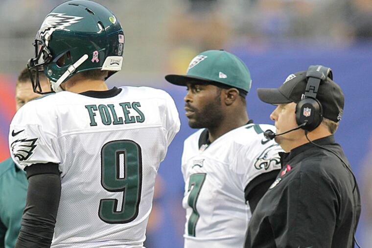 Eagles Head Coach Chip Kelly talks with quarterbacks Nick Foles and Michael Vick. (Steven M. Falk/Staff Photographer)