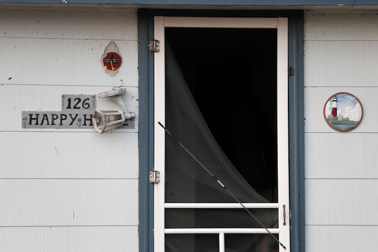 A light fixture hangs in front of a happy home that was damaged on Arnold Boulevard. in the High Bar Harbor section of Long Beach Twp. on N.J.’s Long Beach Island on July 30, 2021. Violent storms, that included tornados, left their marks in both Pa. and N.J. the previous evening.