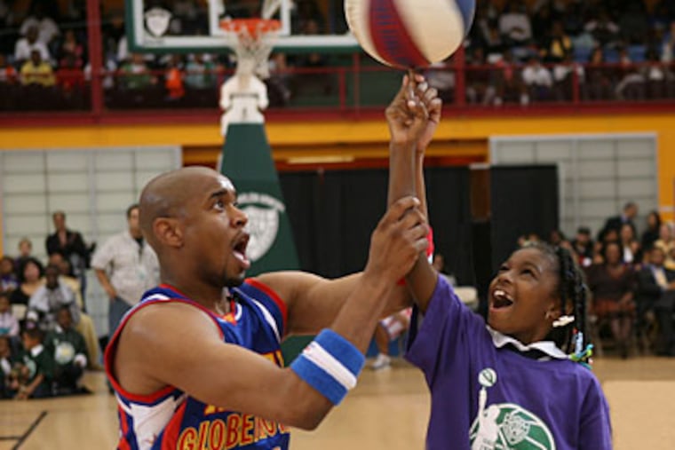 Scooter Christensen of the Harlem Globetrotters shows a young fan how to spin the ball on her finger. (Photo courtesy of the Harlem Globetrotters)