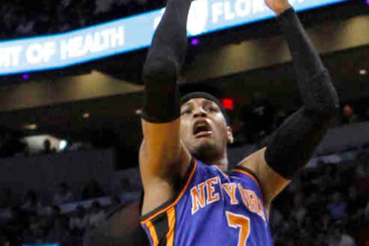 New York's Carmelo Anthony (7) shoots over Miami's LeBron James in the first quarter of the Knicks-Heat game Sunday night. The game ended too late for this edition.