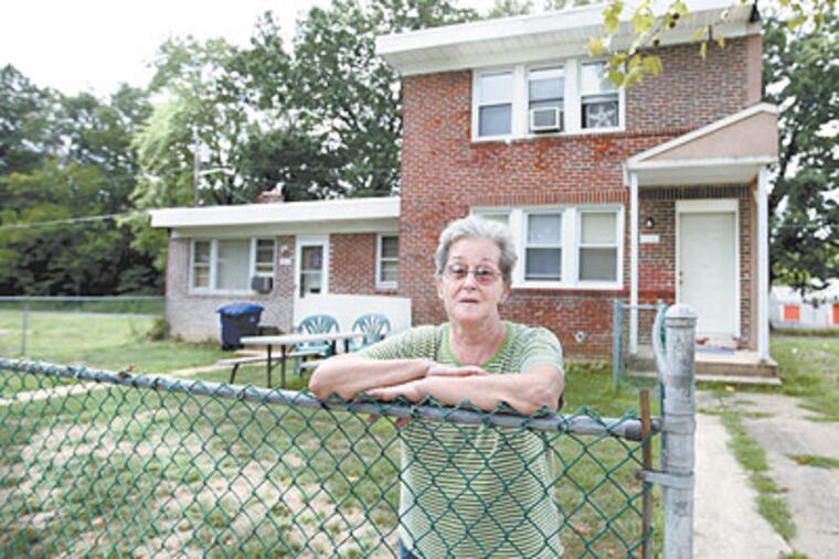 Rosemary Roberts stands in front of her home at 346 South Martin Ave in Mount Holly, NJ . The homes that use to surround it have been torn down and the township of Mount Holly says they will only pay her $55,000 for her home, even though she says she has been paying property taxes on it after it was assessed for $98,000. (Michael Bryant / Staff Photographer)
