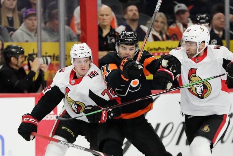 Flyers forward Scott Laughton squeezes between Ottawa's Thomas Chabot (left) and Colin White in a game earlier this season.