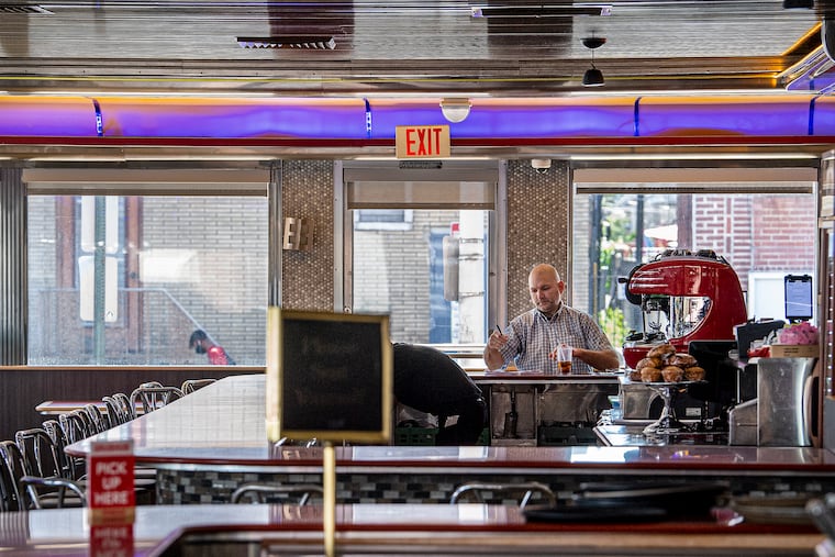 An unidentified man eats at the counter at Melrose Diner in Philadelphia on Tuesday, the first day that indoor dining was permitted to resume in the city.
