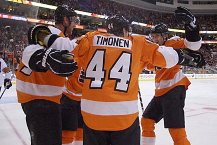 Jeff Carter, Kimmo Timonen and James van Riemsdyk celebrate after Carter's second period goal. (Yong Kim/Staff Photographer)