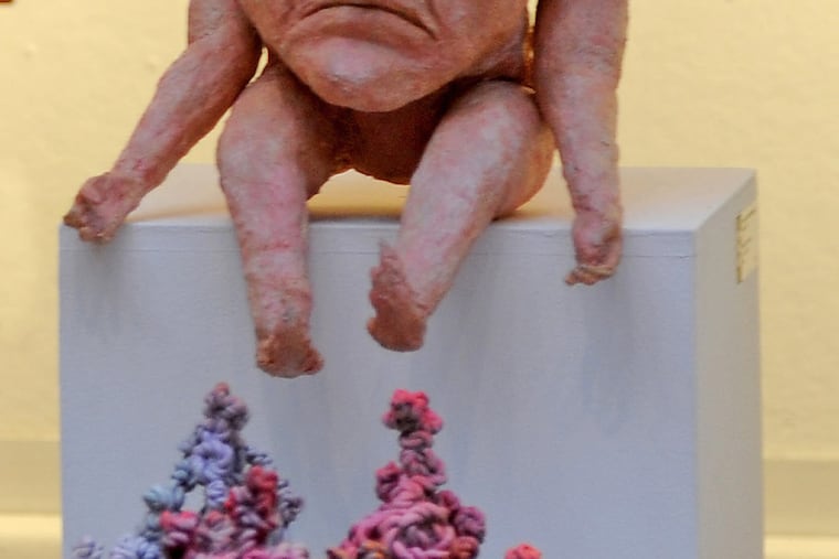 Two pieces exhibited: “Topology A-C” by Tyler Kline (Faculty) a bronze, with “Elf” by Timothy Pots (student, Interdisciplinary Fine Arts, 2016) a mask latex, foam and cotton) above. TOM GRALISH / Staff Photographer