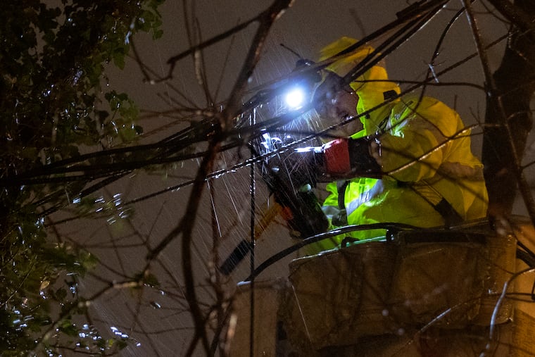 PSE&G troubleshooter Alberto Alfaro works in the pouring rain to restore power to a customer on Church Street in Blackwood, N.J., just before 11 p.m. on Thursday. Storms on Christmas Eve and Christmas morning brought heavy rain and high winds causing flooding, downed trees and power outages to the area.
