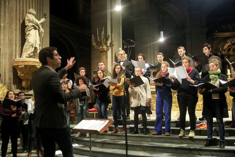 In this photo taken Monday, Dec. 16, 2019, Notre Dame cathedral choir's director Henri Chalet directs the Notre Dame choir during a rehearsal at the Saint Sulpice church in Paris. Notre Dame Cathedral kept holding services during two world wars as a beacon of hope amid bloodshed and fear. It took a fire in peacetime to finally stop Notre Dame from celebrating Christmas Mass for the first time in more than two centuries.