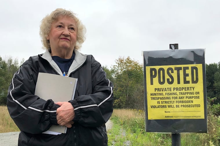 Pennsylvania resident Rose Mary Knick stands next to a private property sign on her farmland in Lackawanna County's Scott Township.