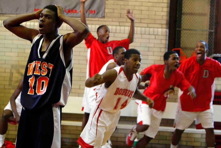 West Philadelphia's Amir Ferebee (left) is stunned after Dobbins' Basir Fulmore hit a game-tying three-pointer from half-court at the buzzer. Dobbins went on to win the game, 77-70, in OT.