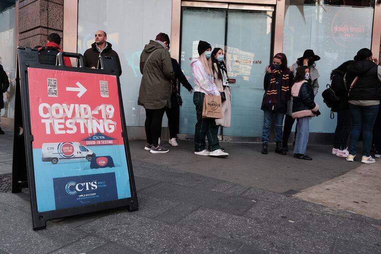 Groups of people line up to get tested for COVID-19 in Times Square on Dec. 5, 2021, in New York City. With the newly discovered omicron strain of COVID, health officials are urging people to get a vaccination or a booster and get tested.