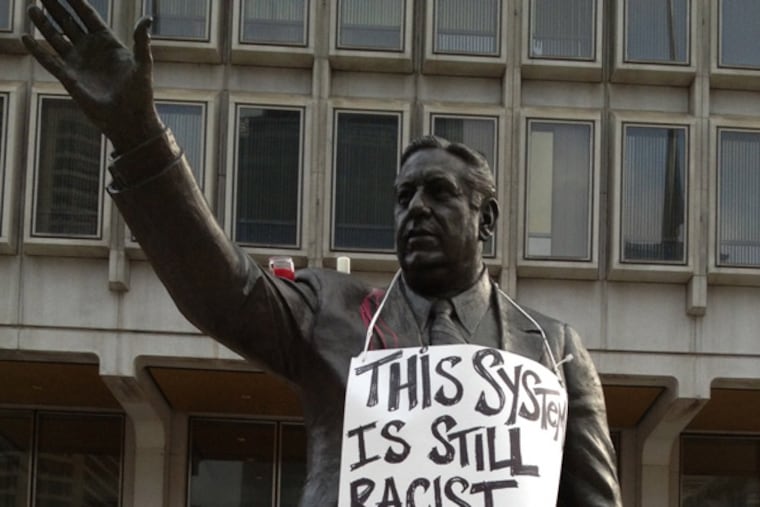 A statue of former Philadelphia Mayor Frank Rizzo in front of the Municipal Services Building on John F. Kennedy Boulevard across from City Hall was decorated with signs protesting the acquittal of George Zimmerman in the fatal shooting of Trayvon Martin.