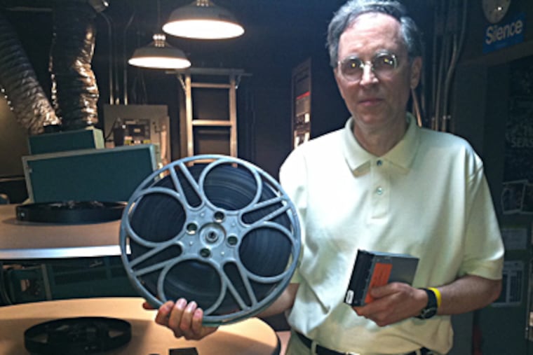 John Toner, executive director of Doylestown’s County Theater, with a reel of 35 mm film and a hard drive with a full-length digital movie. BILL REED / Staff