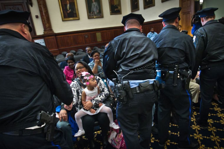 Officers from the 22d Police District pay their respects to Sgt. Robert Wilson III's family, including his sister Shakira Wilson-Burroughs and niece Sytira Burroughs, 2. ALEJANDRO A. ALVAREZ / Staff Photographer