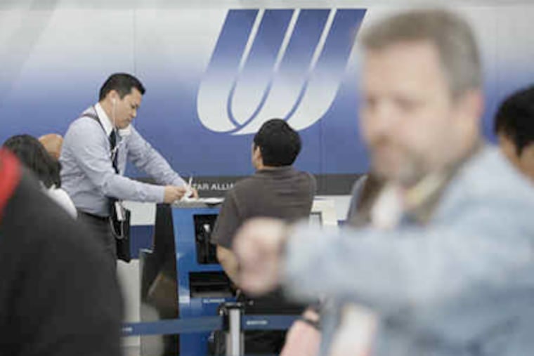 A scene that replays at the nation's airports: A gate agent checks passengers in by hand in Chicago after a computer problem disrupted O'Hare airport flights. This delay occurred July 2. (M. Spencer Green / Associated Press)