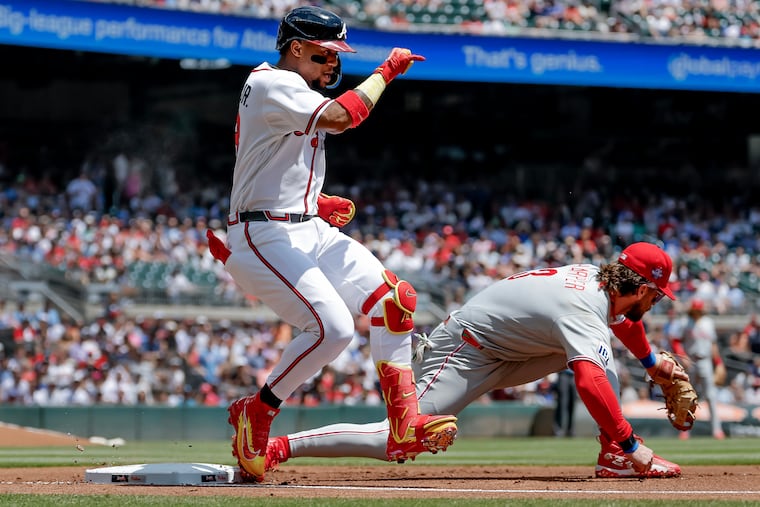 The Braves' Ronald Acuna Jr. legs out an infield single ahead of the throw to Bryce Harper in the first inning, when Atlanta scored three runs.