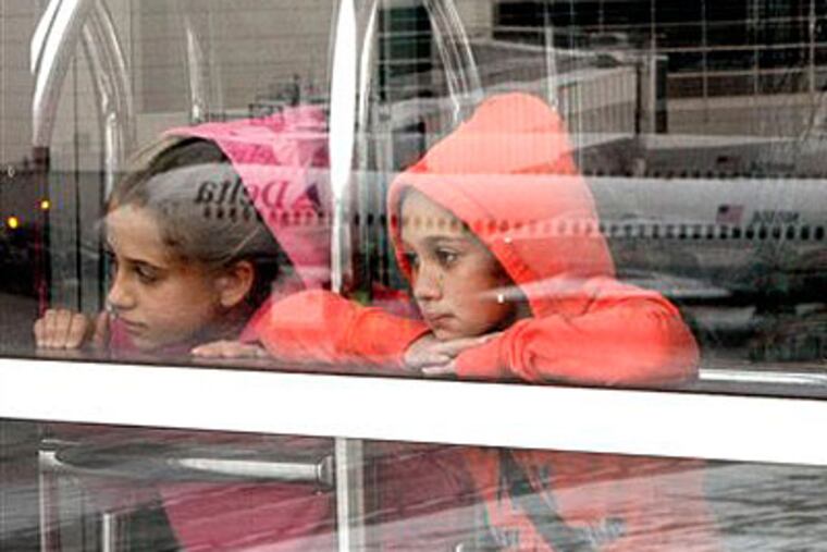 Two sisters watch airplanes at the Detroit airport before they boarded a flight to Florida on Sunday. (AP Photo / Charles Rex Arbogast)