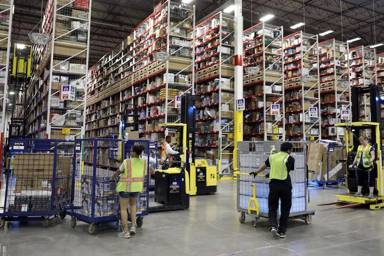 Workers pick items before filling boxes to ship at an Amazon fulfillment center, Aug. 1, 2017, in Romeoville. Now the company is seeking to legalize marijuana nationally so they can hire more people. (Brian Cassella/Chicago Tribune/TNS)