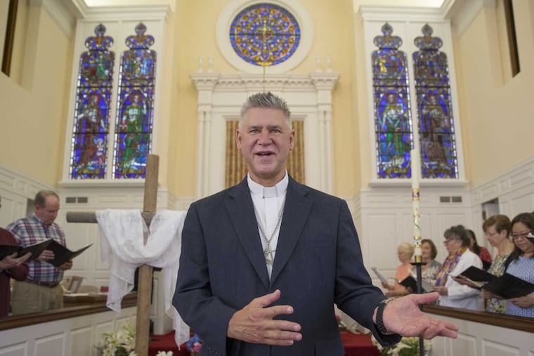 Rev. Timothy Thomson-Hohl, pastor of Ardmore United Methodist Church, rejoices in the Easter Sunday unveiling of four stained glass windows of gospel-writing saints Matthew, Mark, Luke and John that came from Bala Cynwyd UMC after it closed and merged with his congregation.
