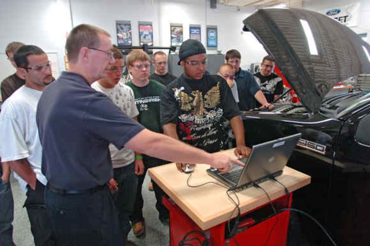 Ed Blaetz, a 1996 grad of the Gloucester County Institute of Technology's automotive education classes and a current instructor, helps student Todd Broscious, 17, with a diagnostic computer.