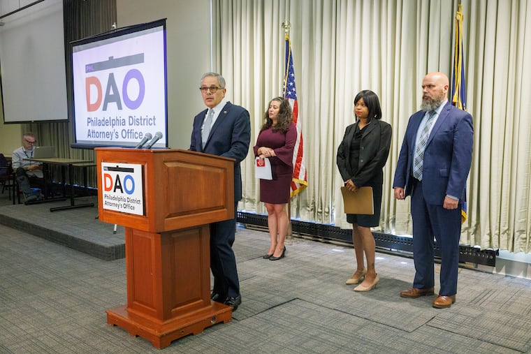 District Attorney Larry Krasner speaks as Assistant District Attorney Karima Yelverton, center, and Clarke Beljean, right, stand behind him. Yelverton and Beljean are leading the criminal case against Mark Dial.