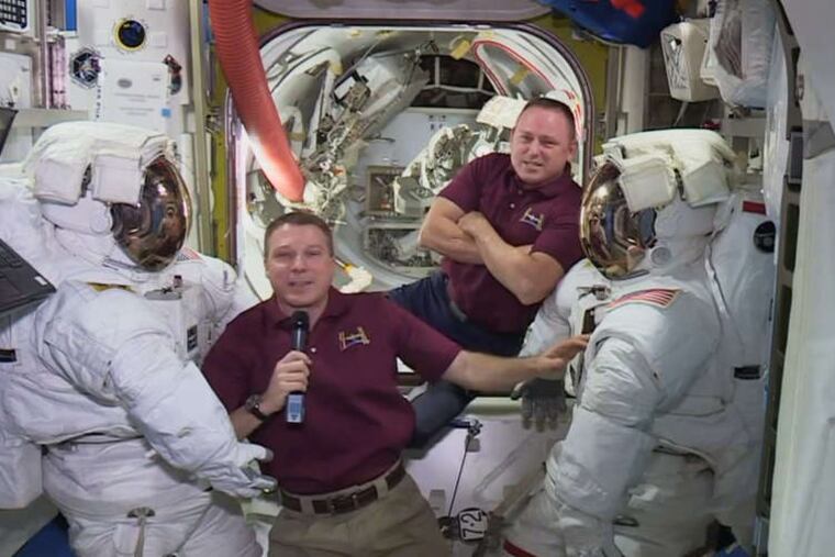 Before their walk, astronauts Terry Virts (left) and Butch Wilmore hung out near their spacesuits aboard the International Space Station during an interview Wednesday. They have two more walks to go.