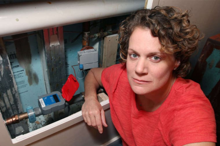 Rebecca Hirsh next to her dreaded water meter.