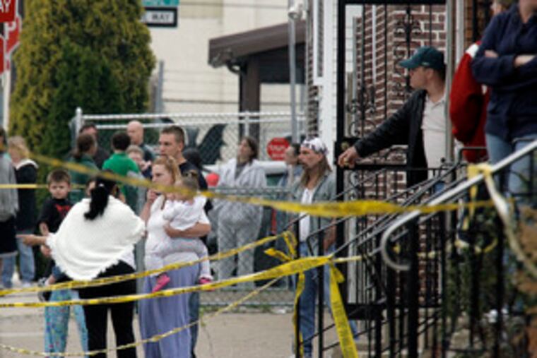 Neighbors gather near the scene of Sgt. Stephen Liczbinski's shooting. "They were holding rags on him trying to stop the blood from pumping out," one neighbor said.