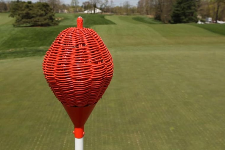 Most golf clubs use flags on their greens to give players a target. Merion uses wicker baskets atop its golf poles. (Michael Bryant/Staff Photographer)