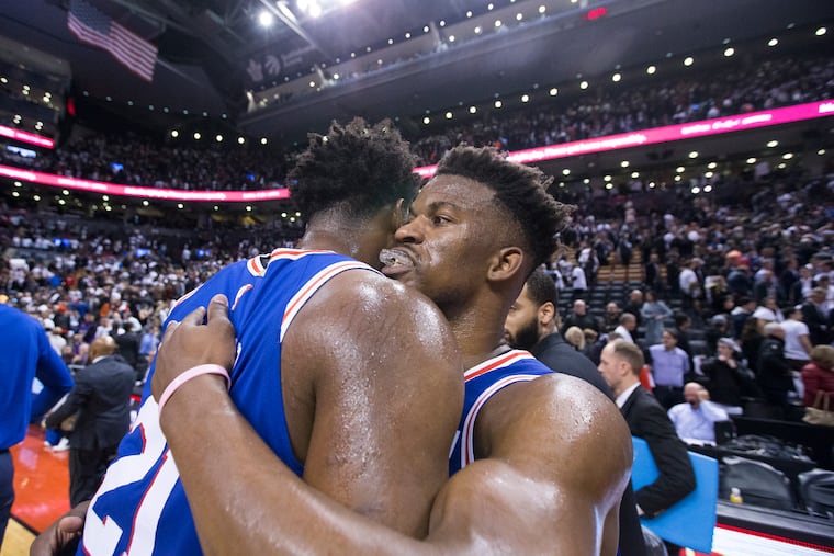 Jimmy Butler gets a hug from Joel Embiid after their victory over the Raptors on Monday.