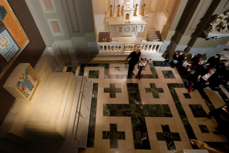 Father Dennis Gill (center) speaks during a news conference to unveil the tomb for St. Katharine Drexel (left) inside the Basilica of Saints Peter and Paul in Philadelphia.