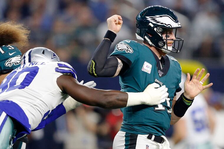 Dallas Cowboys defensive end Demarcus Lawrence (90) strips the ball from Philadelphia Eagles quarterback Carson Wentz (11) during the first half on Sunday, Oct. 20, 2019 at AT&T Stadium in Arlington, Texas. (Vernon Bryant/The Dallas Morning News/TNS)
