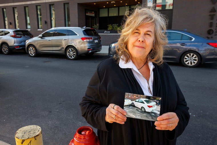 Beanca Gordner, on way to Columbia County, PA., stopped to visit son in Philadelphia when she claims her car was hit by Philadelphia Parking Authority vehicle. She is holding a photograph of her vehicle after it was pushed onto the sidewalk behind her. Photograph taken Wednesday morning April 2, 2025 along Bainbridge just east of S. Broad Street.