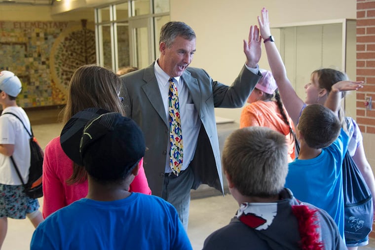 Mark Klein, superintendent of the Council Rock district for 11 years, slaps high-fives with pupils at Goodnoe Elementary. Klein, who began his career as a grade-school teacher and also was a principal at three schools, is retiring. (CLEM MURRAY / Staff Photographer)