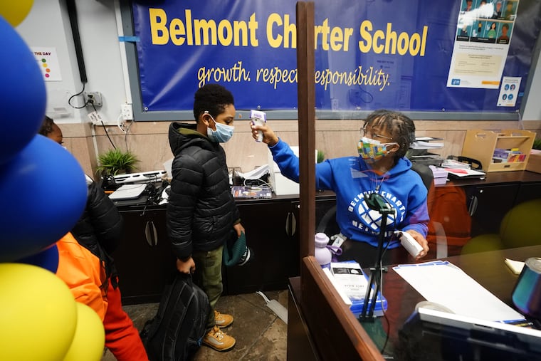 Student Lamir Smith (left) has his temperature taken by Admin Assistant Lakita Williams at Belmont Charter School in February.