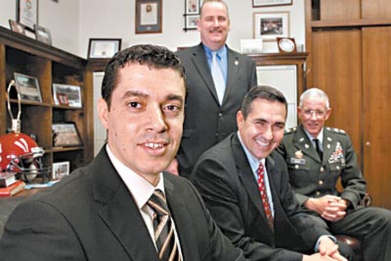 Safa Ismael (left) with Patrick Dugan, State Rep. Bryan Lentz, and Lt. Col. Jeffrey Voice. They helped Ismael immigrate to the United States after he was targeted for working with them in Iraq. (LAURENCE KESTERSON / Staff Photographer)