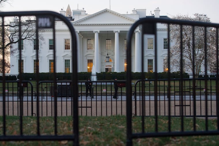 In this March 24, 2019 photo, The White House is seen behind security barriers in Washington. A White House official turned whistleblower says dozens of people in President Donald Trump’s administration were granted access to classified information despite “disqualifying issues” in their backgrounds including concerns about foreign influence, drug use and criminal conduct.