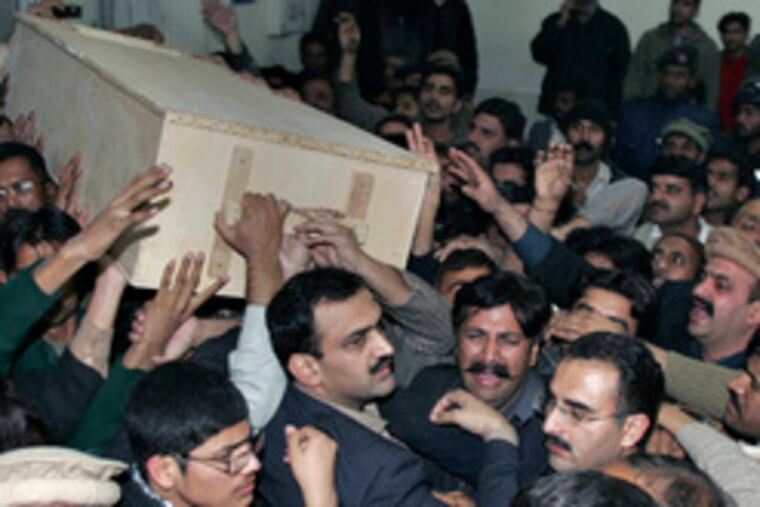 A coffin bearing the body of Benazir Bhutto is carried from a Rawalpindi hospital, where hundreds had gathered. It was later flown, with the former prime minister's husband and children, to southern Pakistan, where her family has roots .