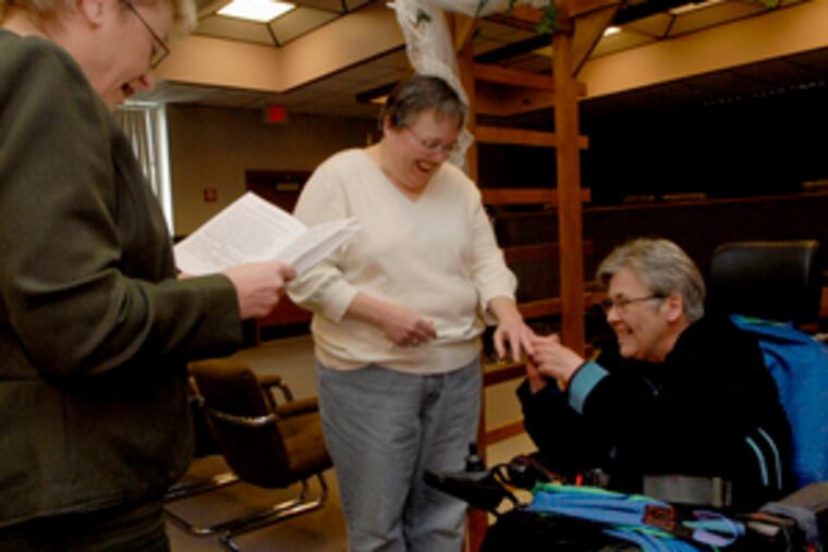 Trish McClellan (center) and Nancy Groff exchange rings during a civil union ceremony in Gloucester Township, Mayor Cindy Rau-Hatton officiating.
