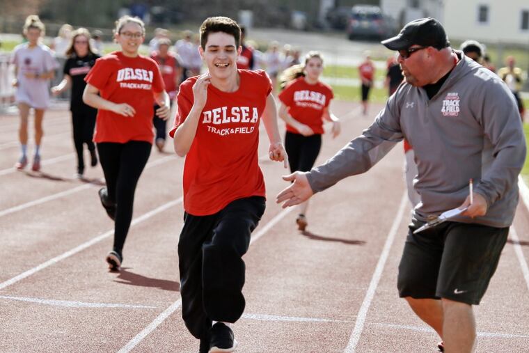 Delsea track and field coach Ronn Flaim encourages Crusaders senior Noah Bekeshka during the Unified Sports track meet.