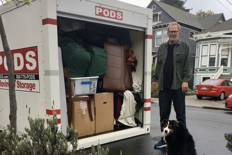 Kevin Keane, under the watchful eyes of Bailey the dog, finishes packing a Pod in California for a move to Delaware.