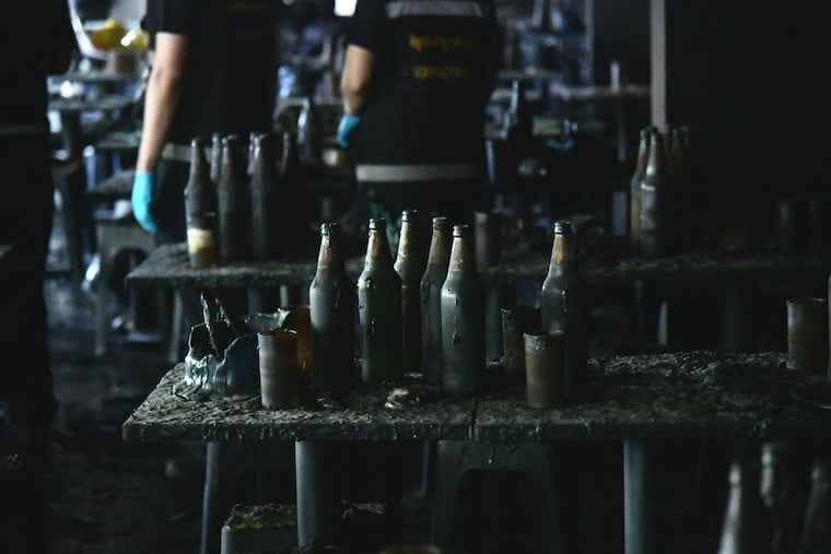 In this handout photo released by Bangkok Metropolitan Administration, bottles are seen on a table at the site of a fire in Bangkok, Thailand, Monday, July 13, 2026.