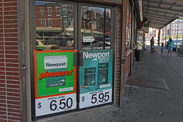 This small store at 9th and Washington features large tobacco ads on its doors. A new report faults convenience stores and groceries in Philly's poorer neighborhoods for featuring too many cigarette signs and ads that could help turn kids into smokers. (MICHAEL BRYANT / Staff Photographer)