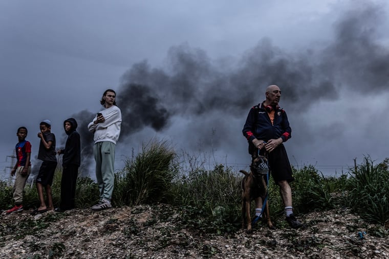People gather on a small hill in Holon, Israel, to get a glimpse of the aftermath of the interception of a barrage from Iran on March 13.