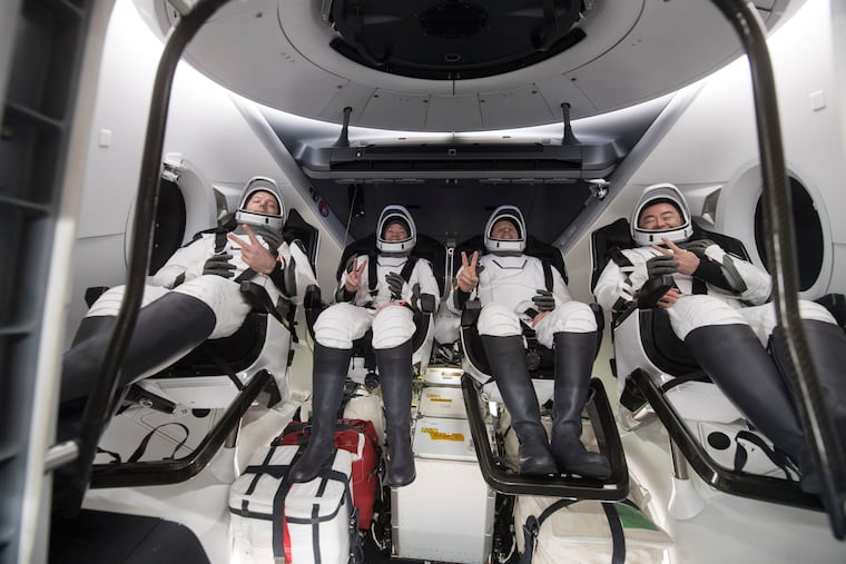 From left to right, European Space Agency astronaut Thomas Pesquet, NASA astronauts Megan McArthur and Shane Kimbrough, and Japan Aerospace Exploration Agency astronaut Akihiko Hoshide gesture inside the SpaceX Dragon spacecraft onboard the SpaceX GO Navigator recovery ship shortly after having landed in the Gulf of Mexico off the coast of Pensacola, Fla., Monday, Nov. 8, 2021. The astronauts returned to Earth on Monday to end a 200-day space station mission that began last spring.