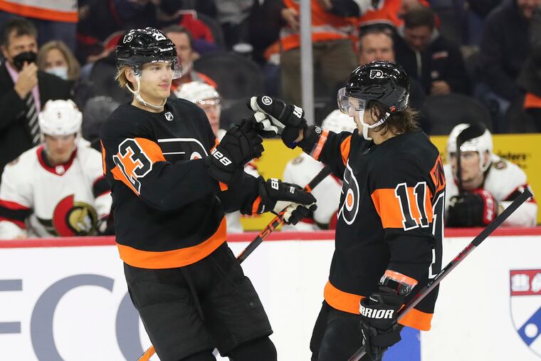 Flyers left wing Oskar Lindblom celebrates his first period goal with teammate right wing Travis Konecny against the Ottawa Senators on Saturday, December 18, 2021 in Philadelphia.