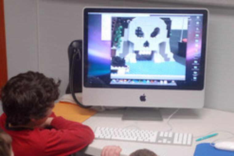 Boys in Daniel Legoff's therapy group gather around a computer to watch a movie made with Lego toys by one of the children.