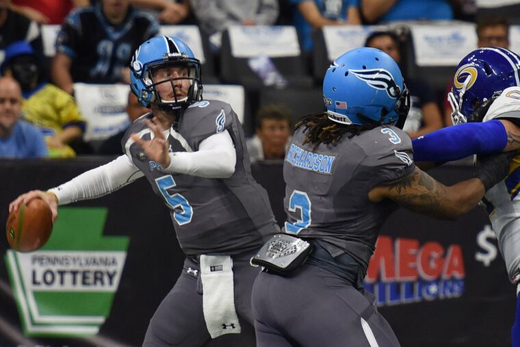 Philadelphia Soul Quarterback DAn Raudabaugh, left, looks downfield for a receiver as Jermaine Richardson, center and Tampa Bay Storm's DAvid Washington, right, battle it out in the first quarter of Round One Arena Football playoff game Sunday Aug. 7, 2016 in Allentown, Pa. (Bradley C Bower/Philadelphia Inquirer)
