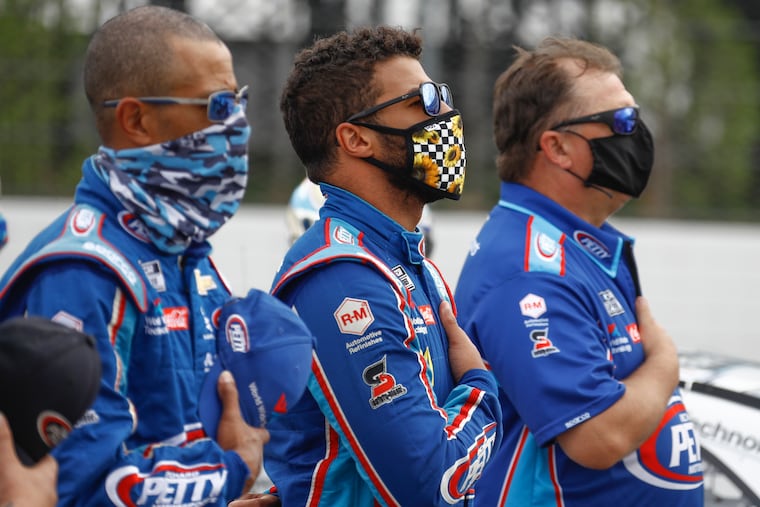 Bubba Wallace (center) stands with his crew during the playing of the national anthem before a scheduled NASCAR Cup Series auto race at Pocono Raceway, Saturday, June 27, 2020, in Long Pond, Pa.