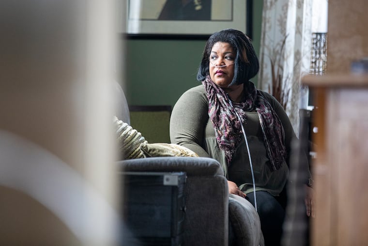 Joy Ezekiel-Gibson, 47, of Atco, N.J., poses for a portrait at her home on Thursday, March, 4, 2021. Joy was sick with COVID-19 last March. She was hospitalized for 30 days. She has been on oxygen since May.
